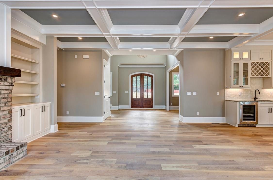 Open-concept living area with coffered ceiling and built-in shelving
