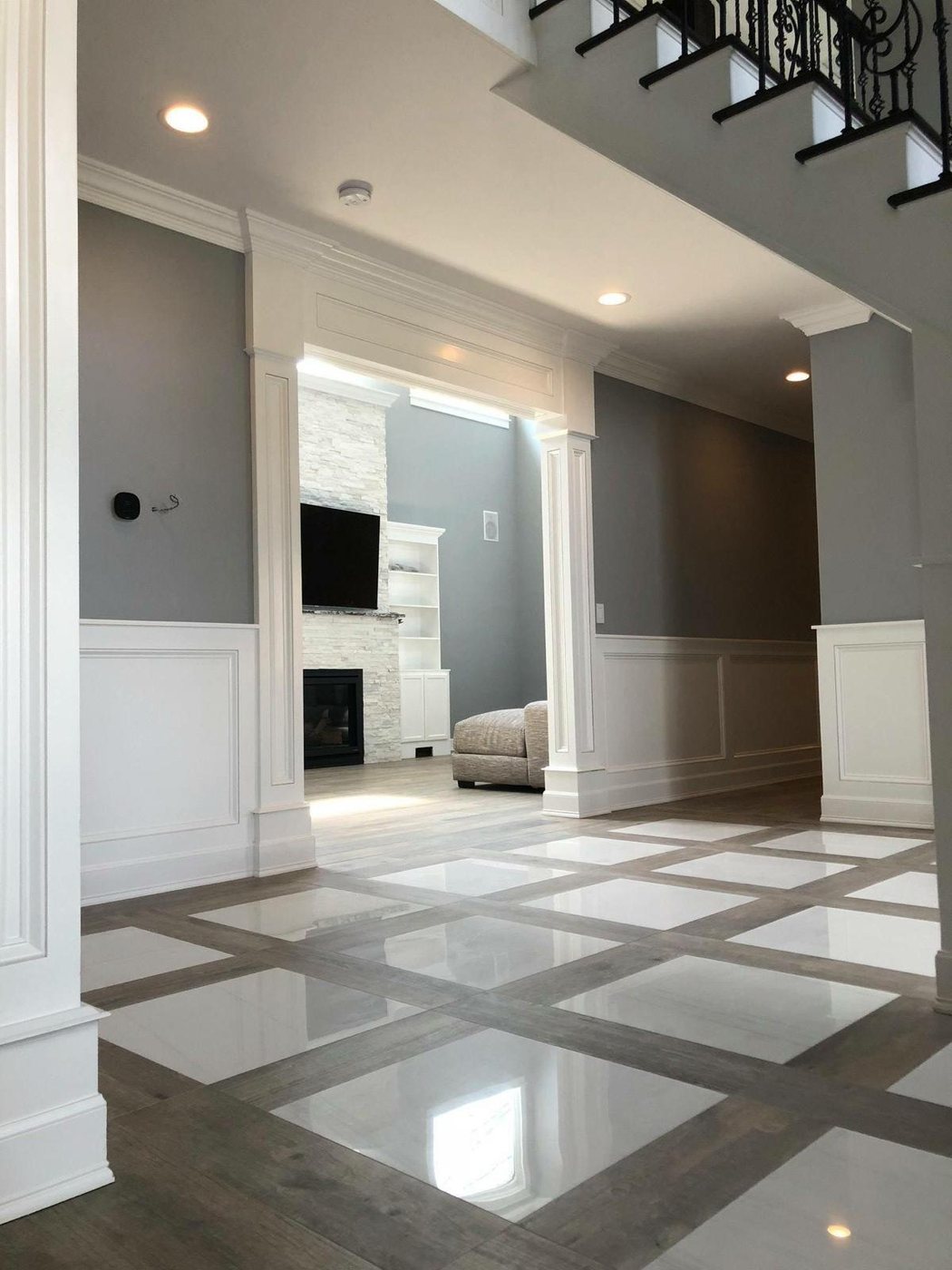 Marble entryway with custom inlay pattern and staircase