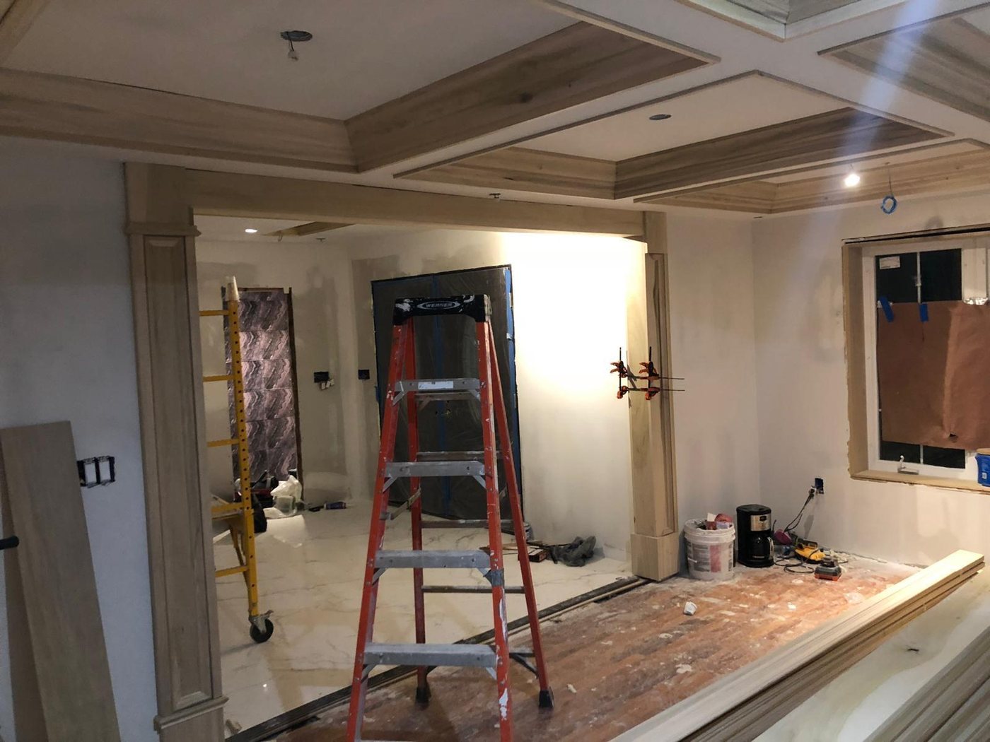 Custom millwork installation in progress with coffered ceiling framing