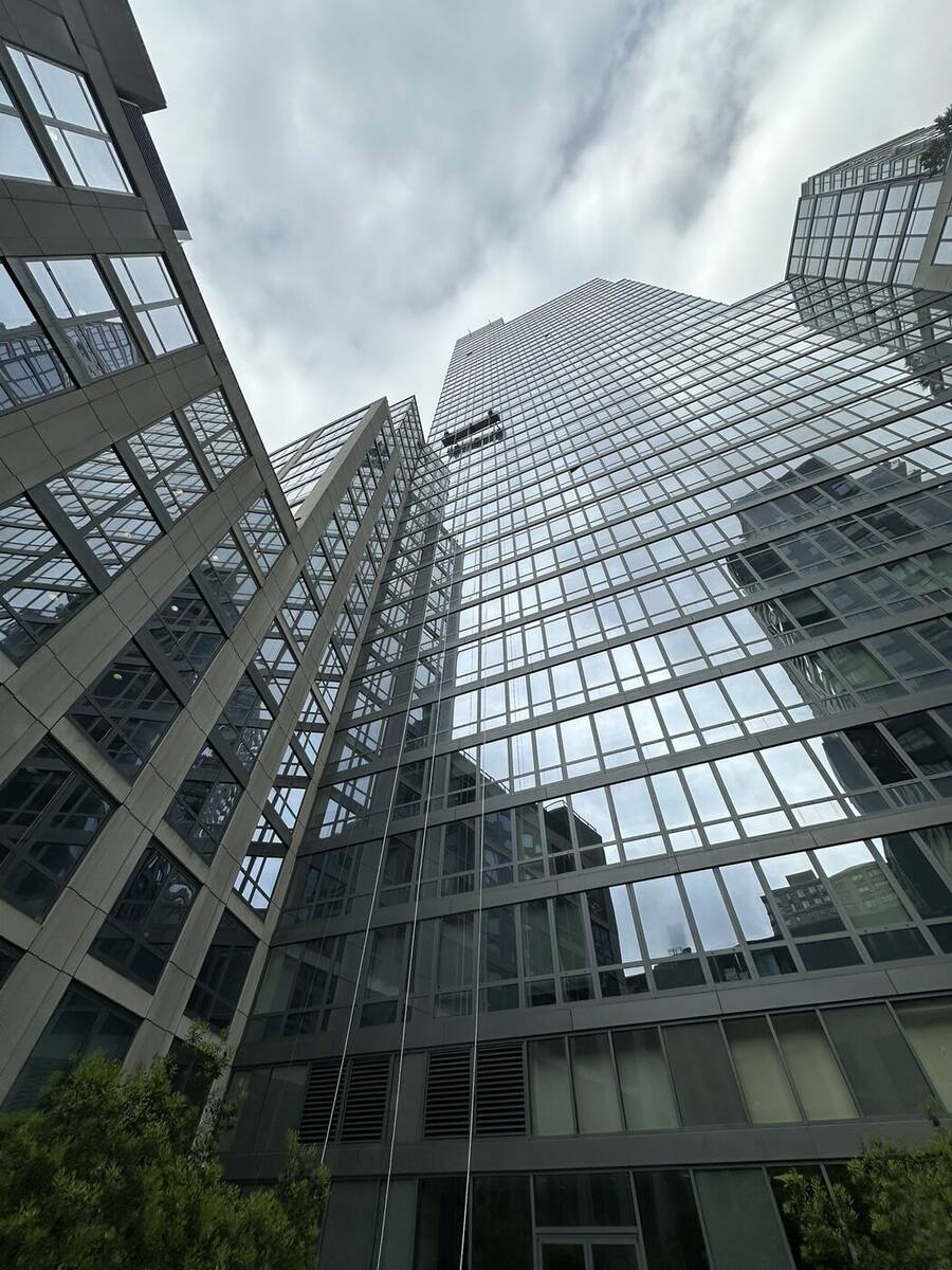 Overhead protection structure spanning a city sidewalk